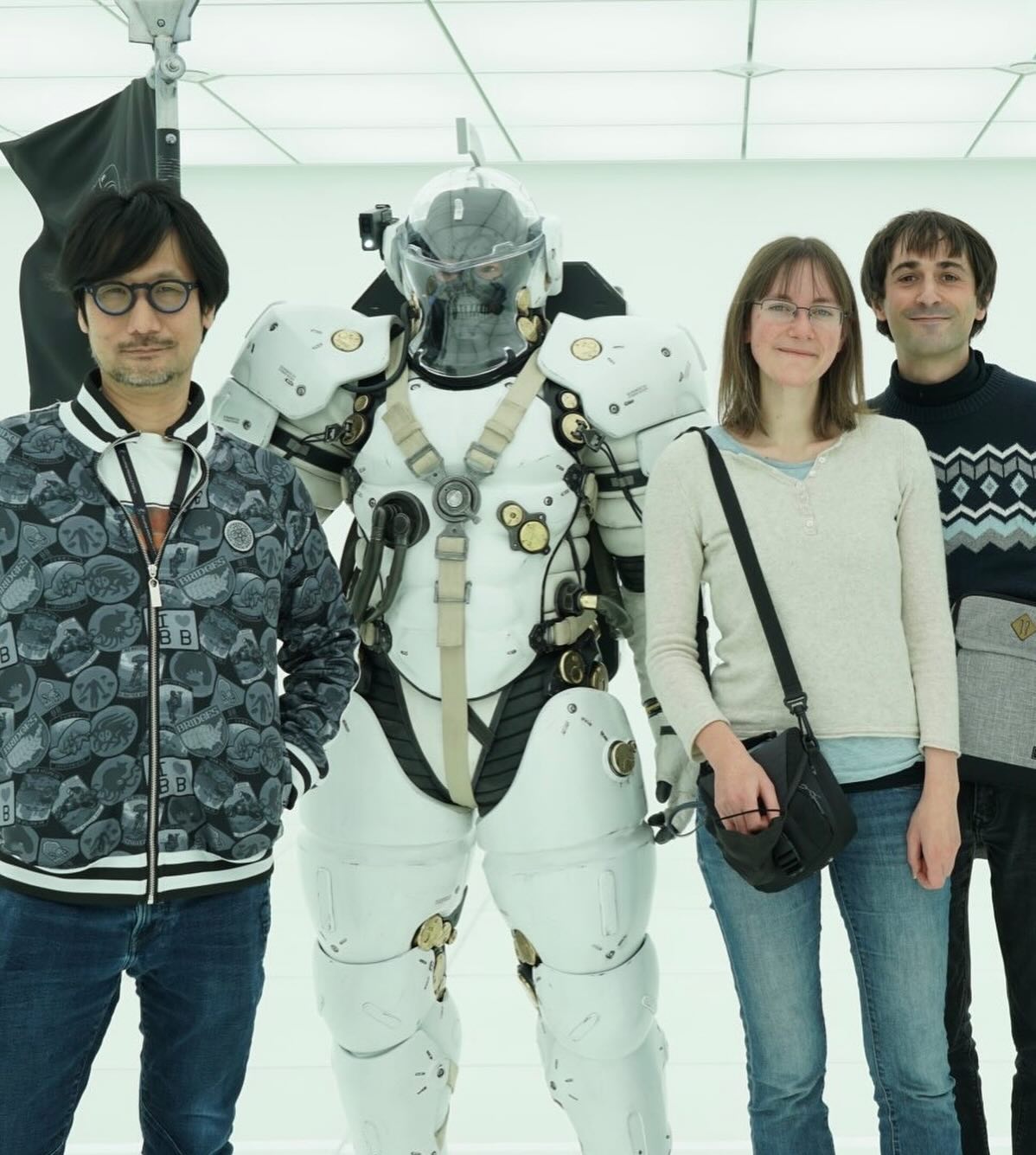 Cécile Brun e Olivier Pichard di Atelier Sentô accanto a Hideo Kojima e a un personaggio in tuta armata bianca.