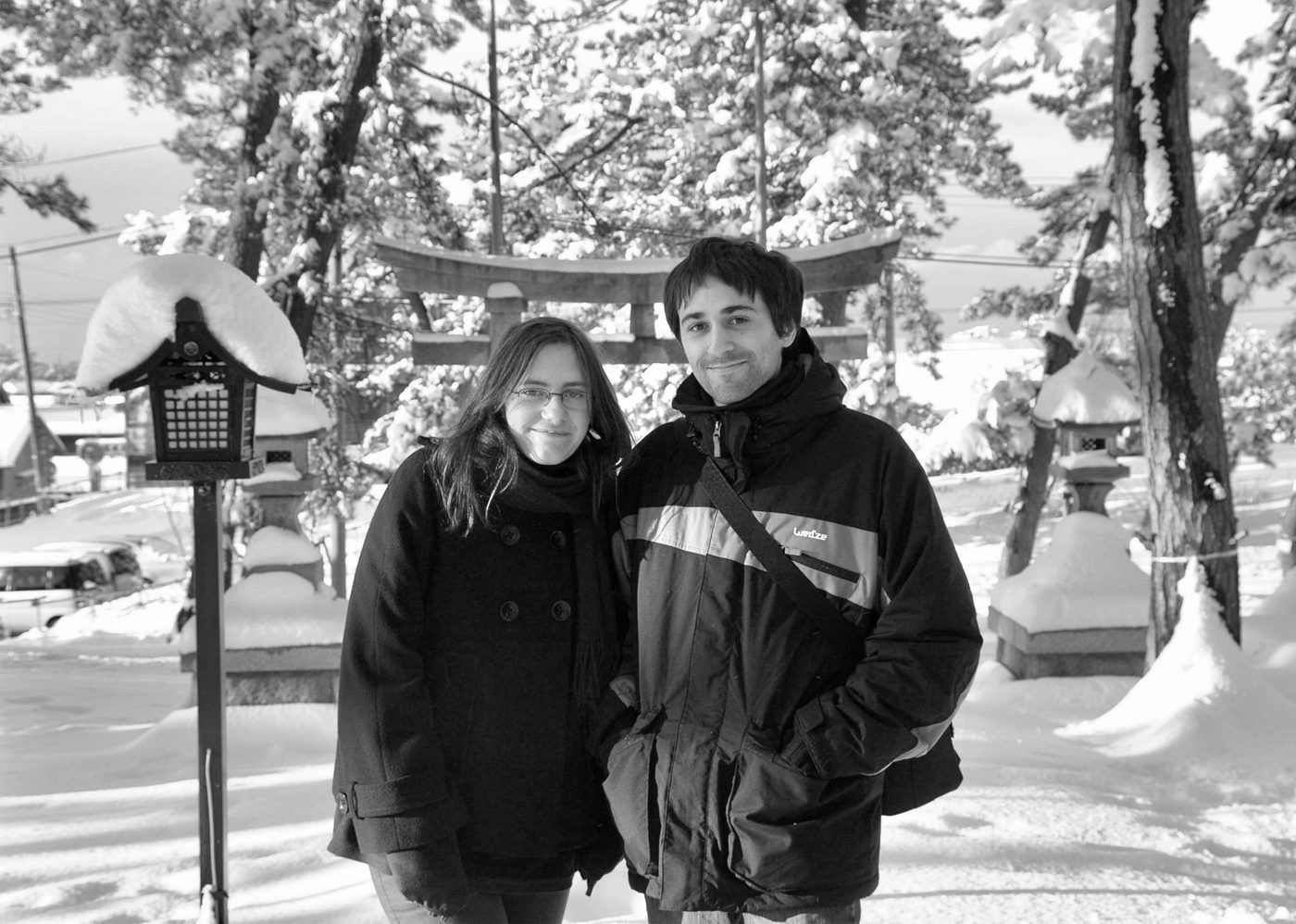 I due autori di Atelier Sentô, Cécile Brun e Olivier Pichard, sorridenti sotto la neve davanti a un torii in Giappone.